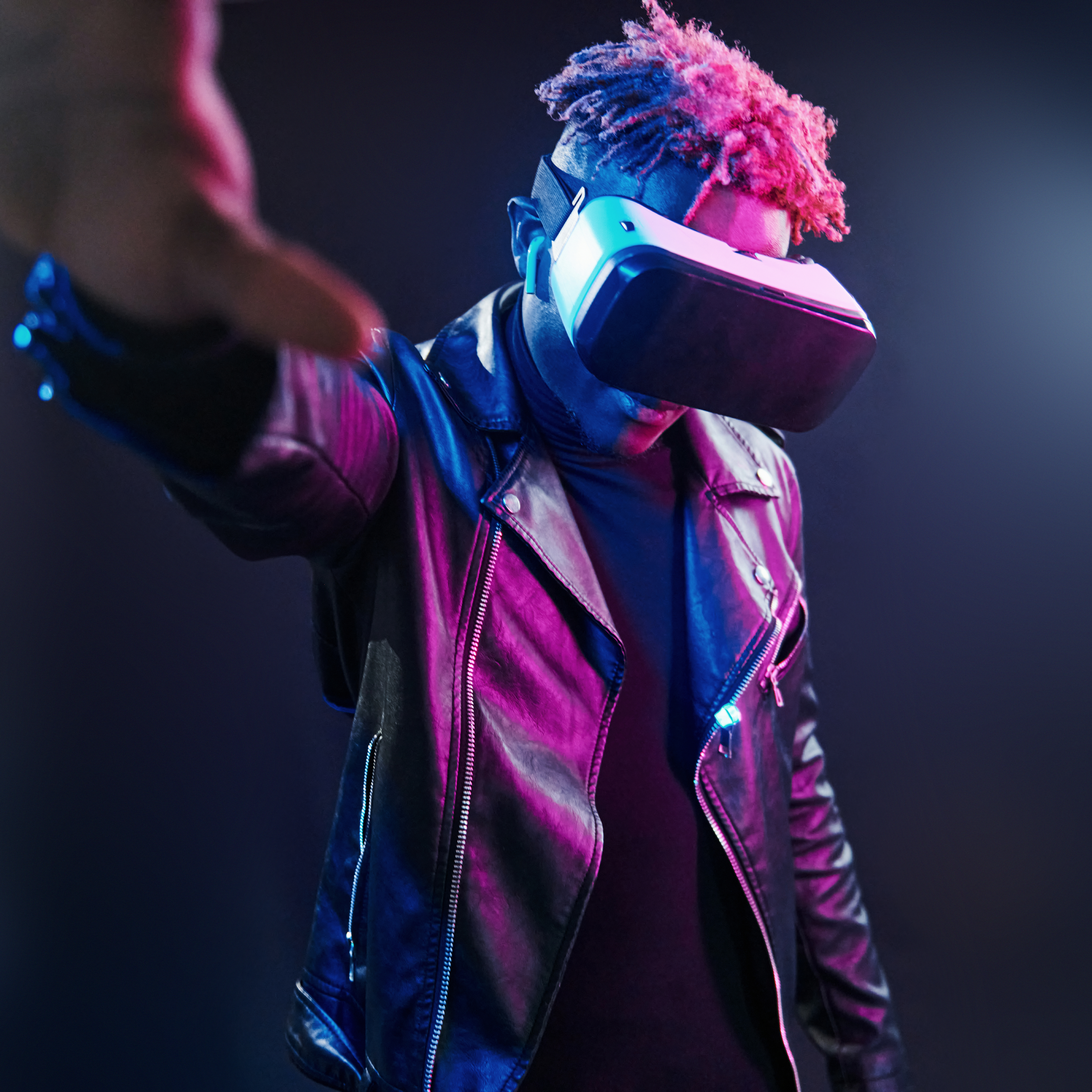 Virtual reality experience. Futuristic neon lighting. Young african american man in the studio